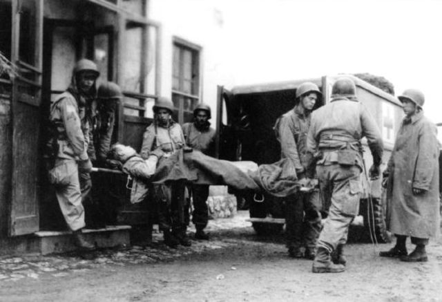 Paracaidistas del 504th Parachute Infantry Regiment cargando un herido en una ambulancia. 24 de enero de 1944
