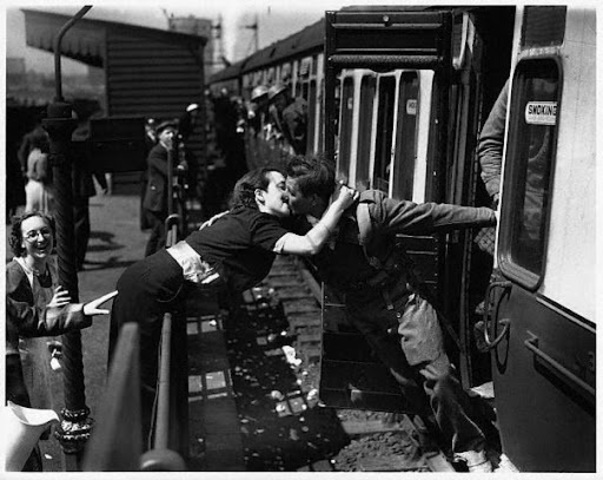 Londres, 1940. Una mujer se inclina sobre la barandilla para besar a un soldado británico de regreso a la lucha