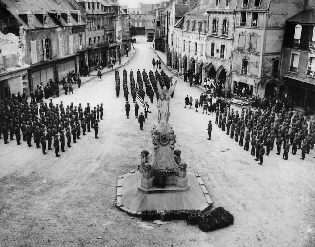 Las tropas estadounidenses desfilando en la Plaza de la ciudad, en Carentan